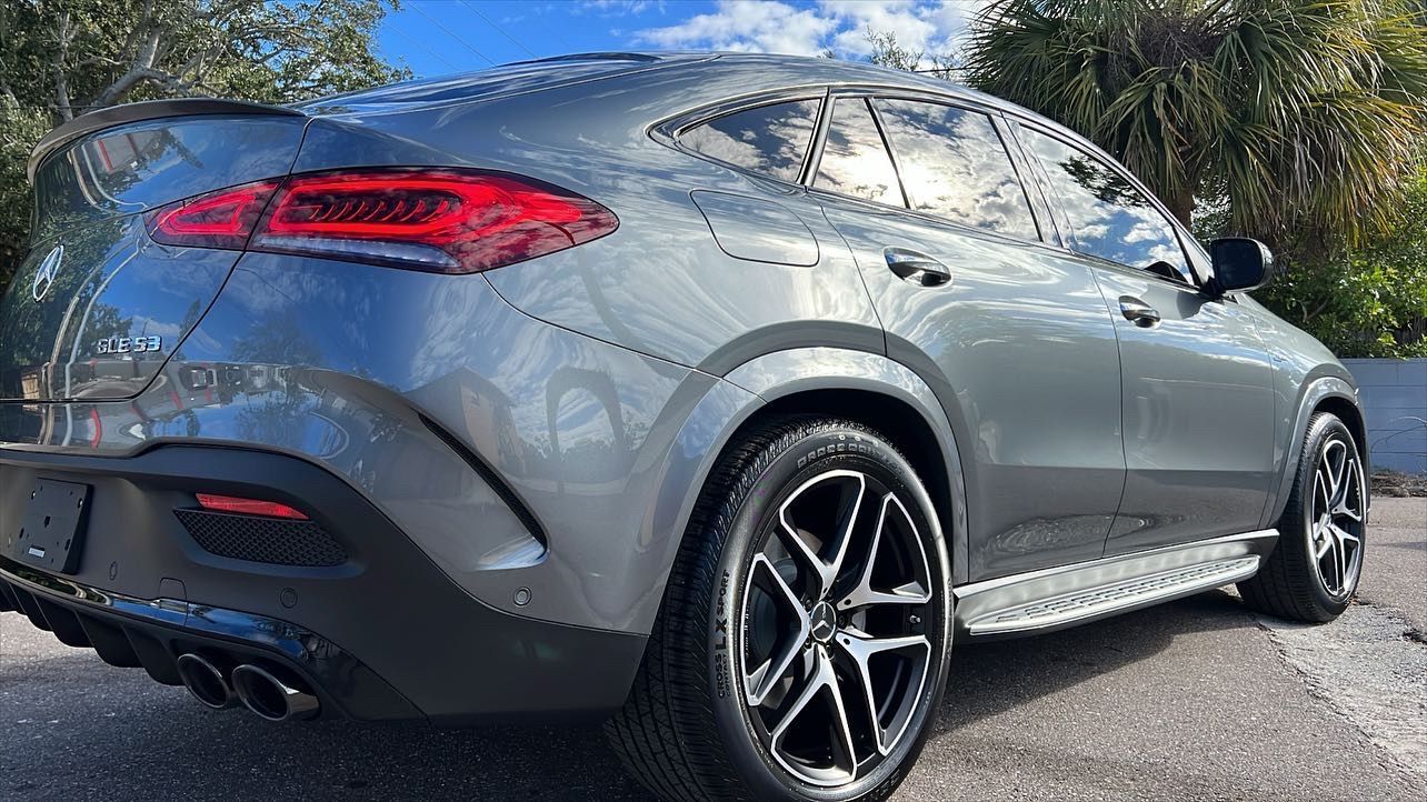 A gray mercedes benz gle 450 4matic is parked on the side of the road.