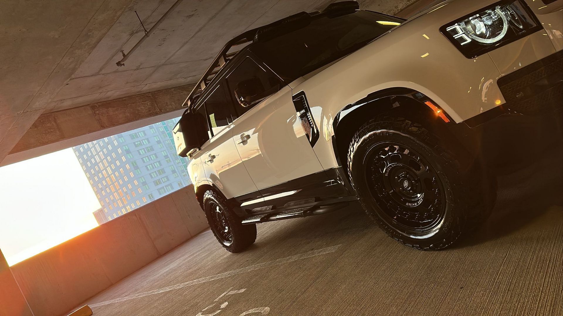 A white suv is parked in a parking garage.