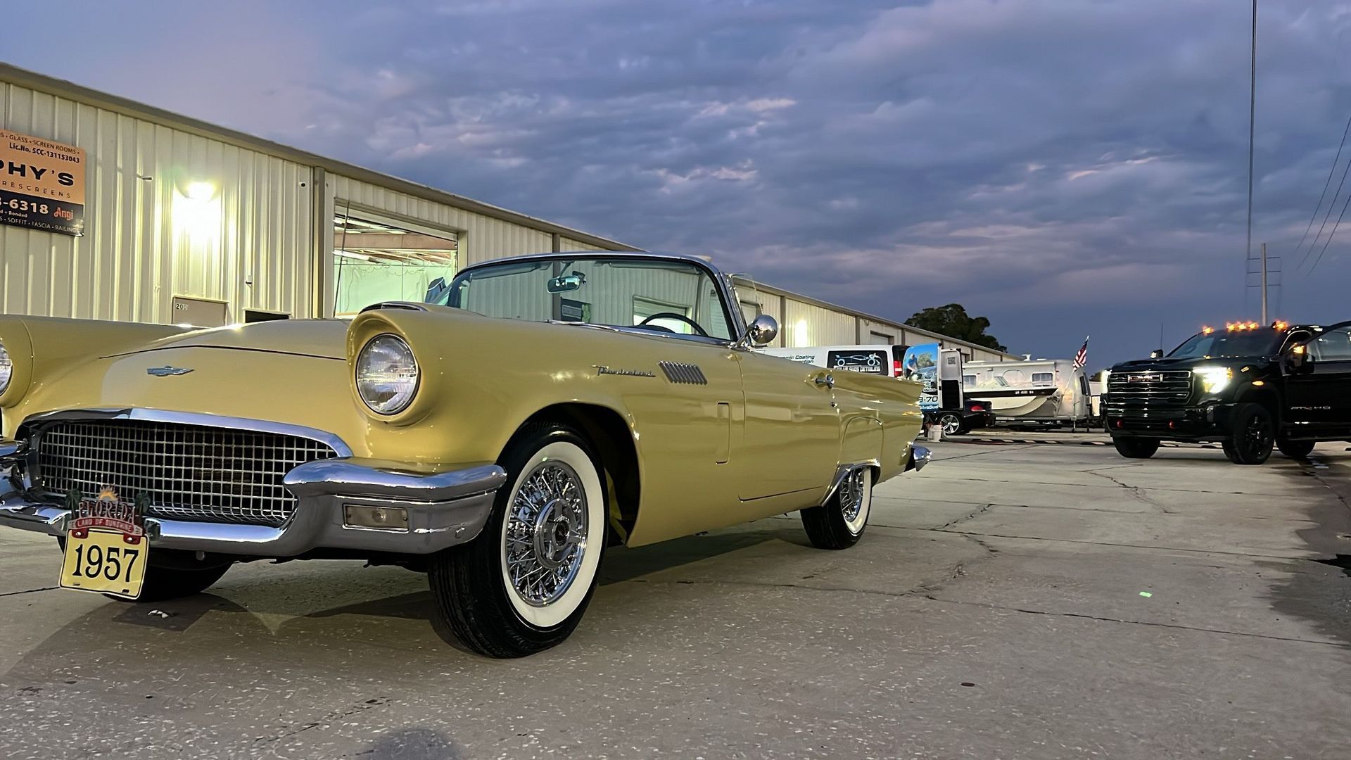 A yellow car is parked in front of a building.