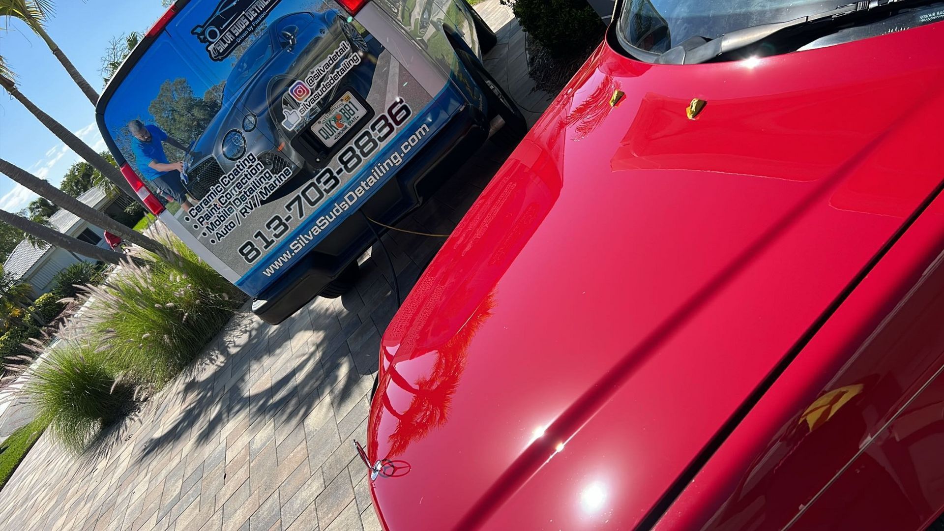 A red car is parked next to a blue van.