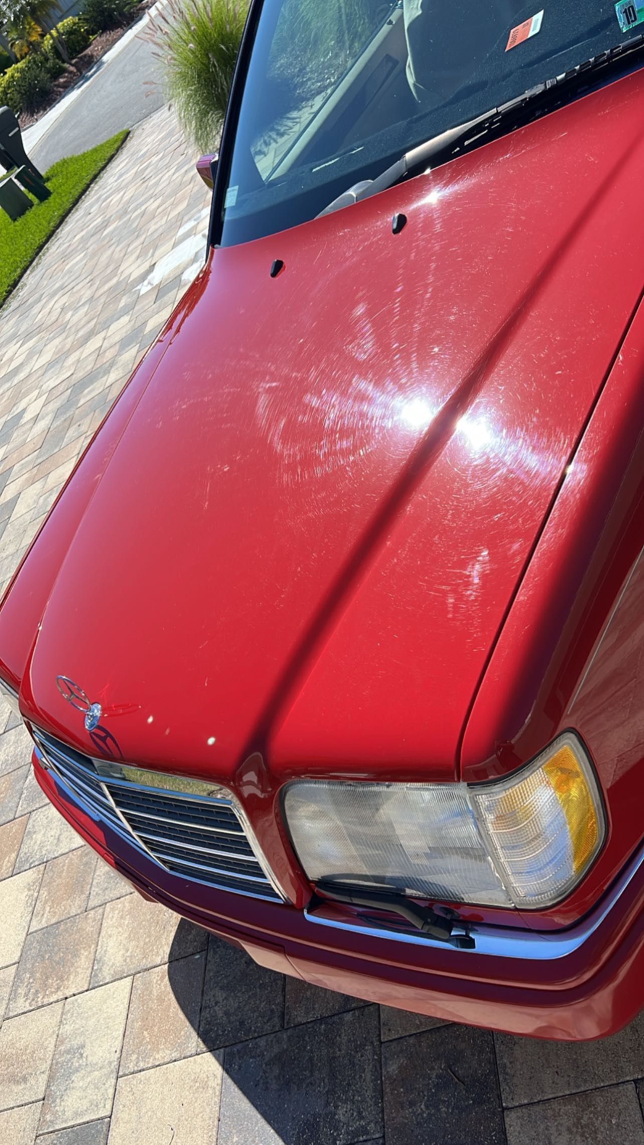 A red car is parked on the side of the road.