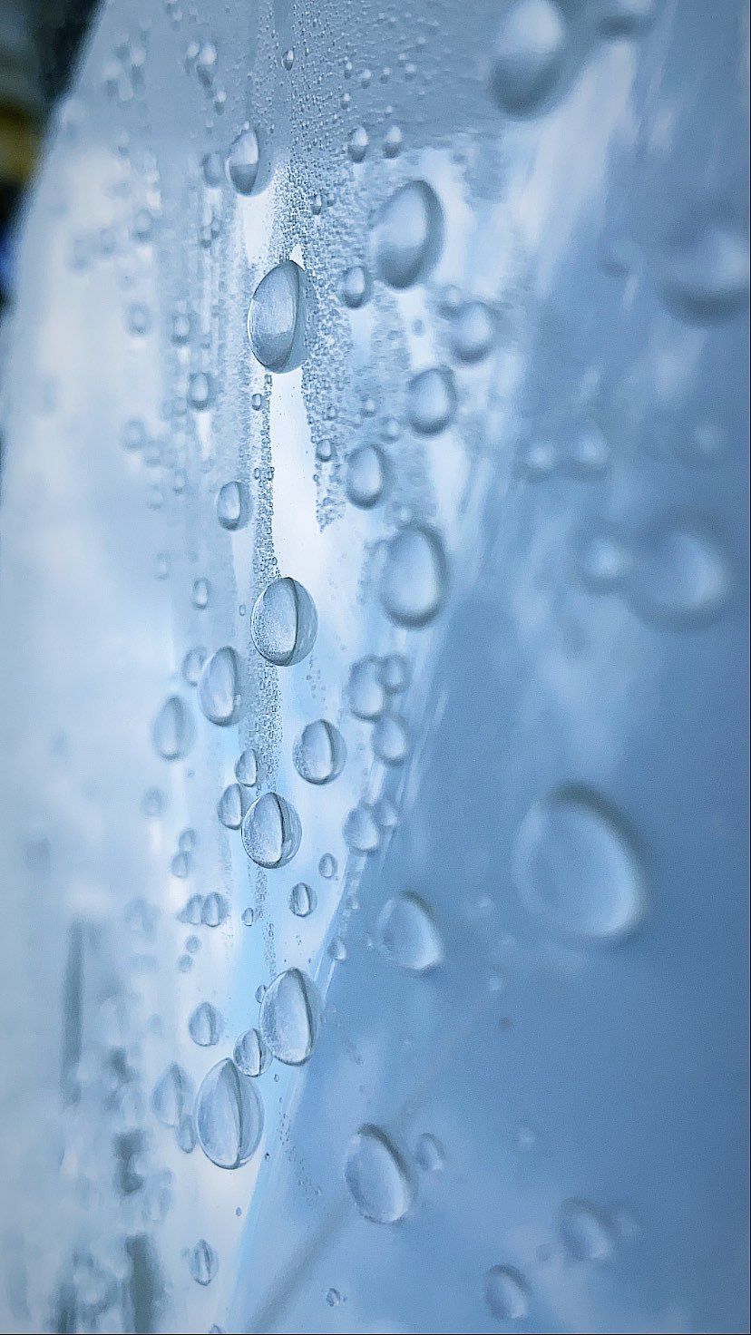 A close up of water drops on a blue surface