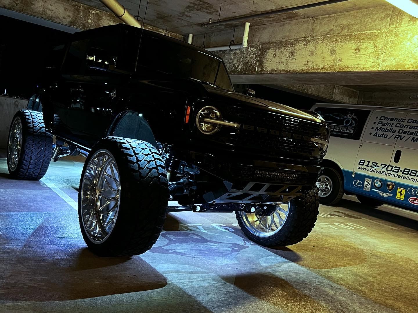 A black jeep is parked in a parking garage