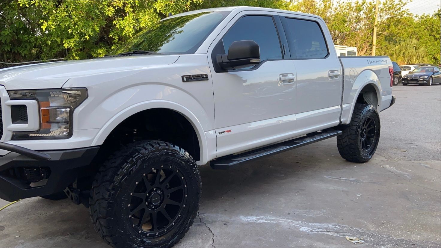 A white ford f150 truck is parked in a parking lot.