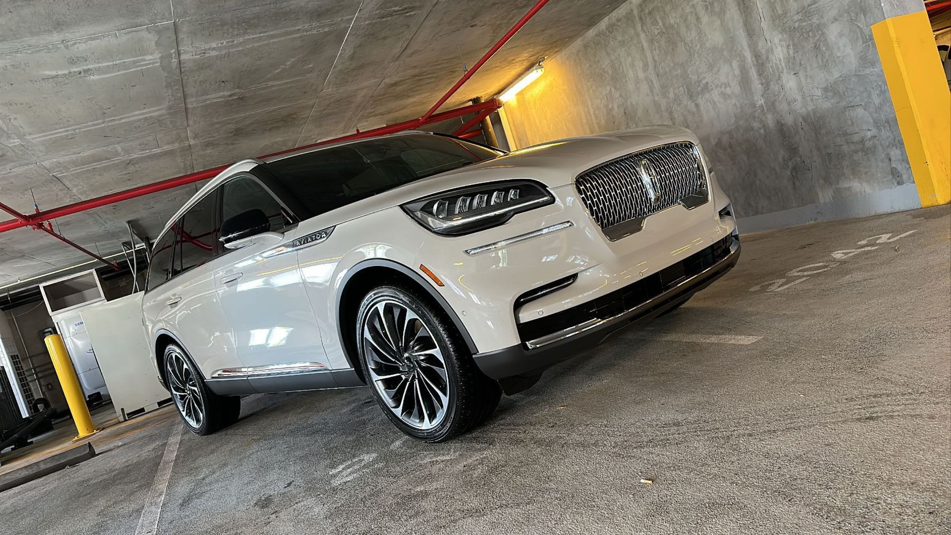 A white car is parked in a parking garage.