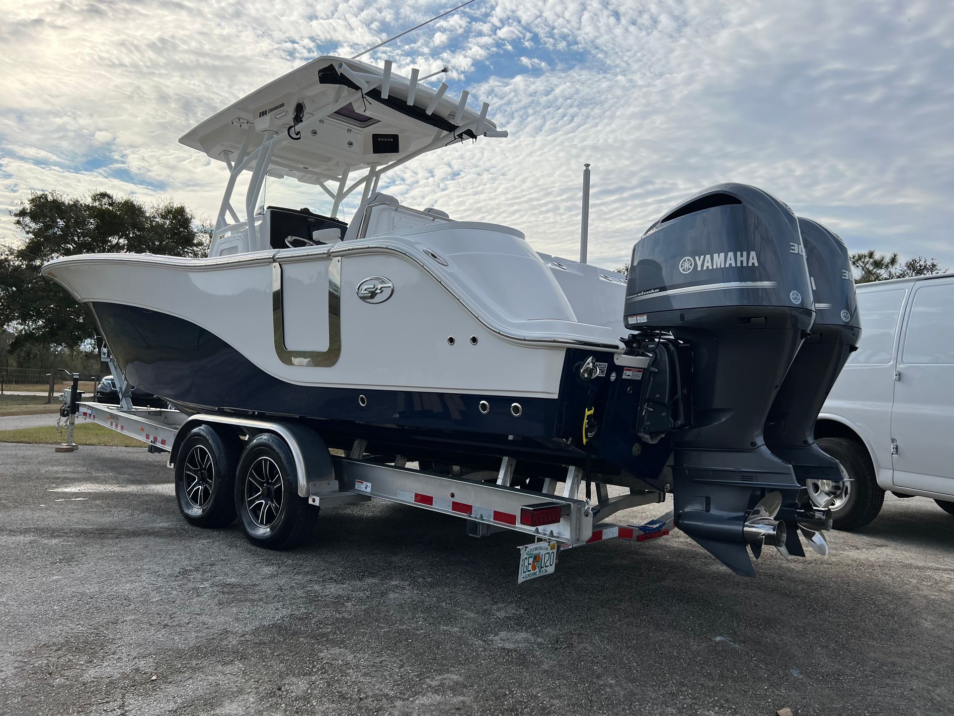A boat is parked on a trailer in a parking lot.