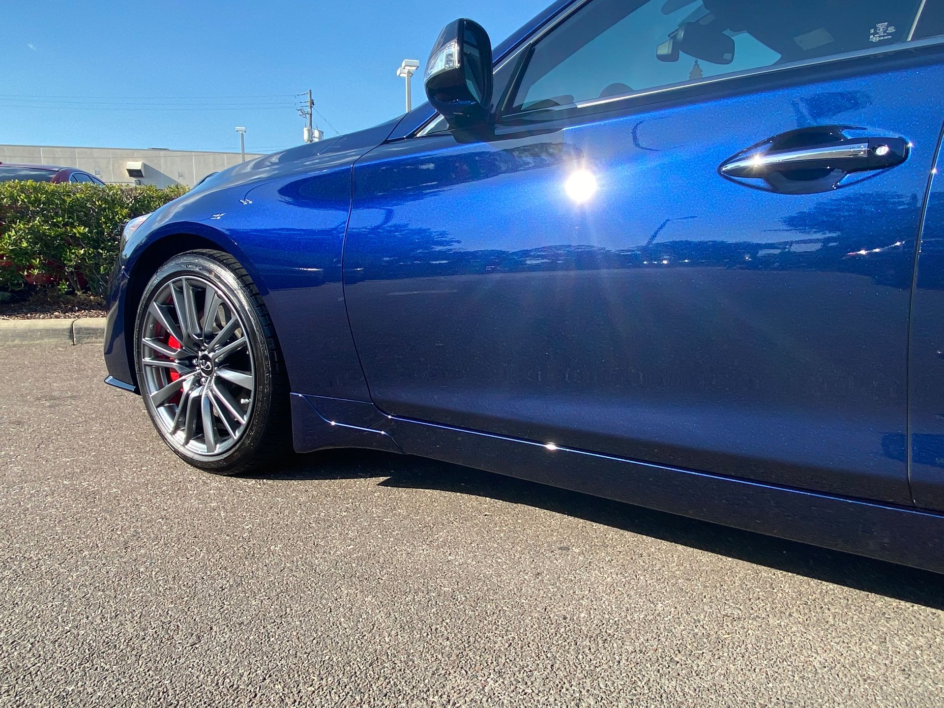 A blue car is parked on the side of the road.