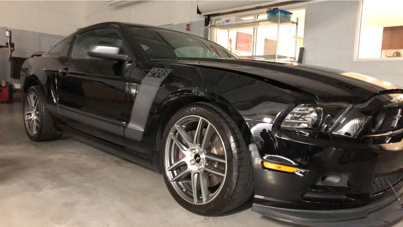 A black ford mustang is parked in a garage.