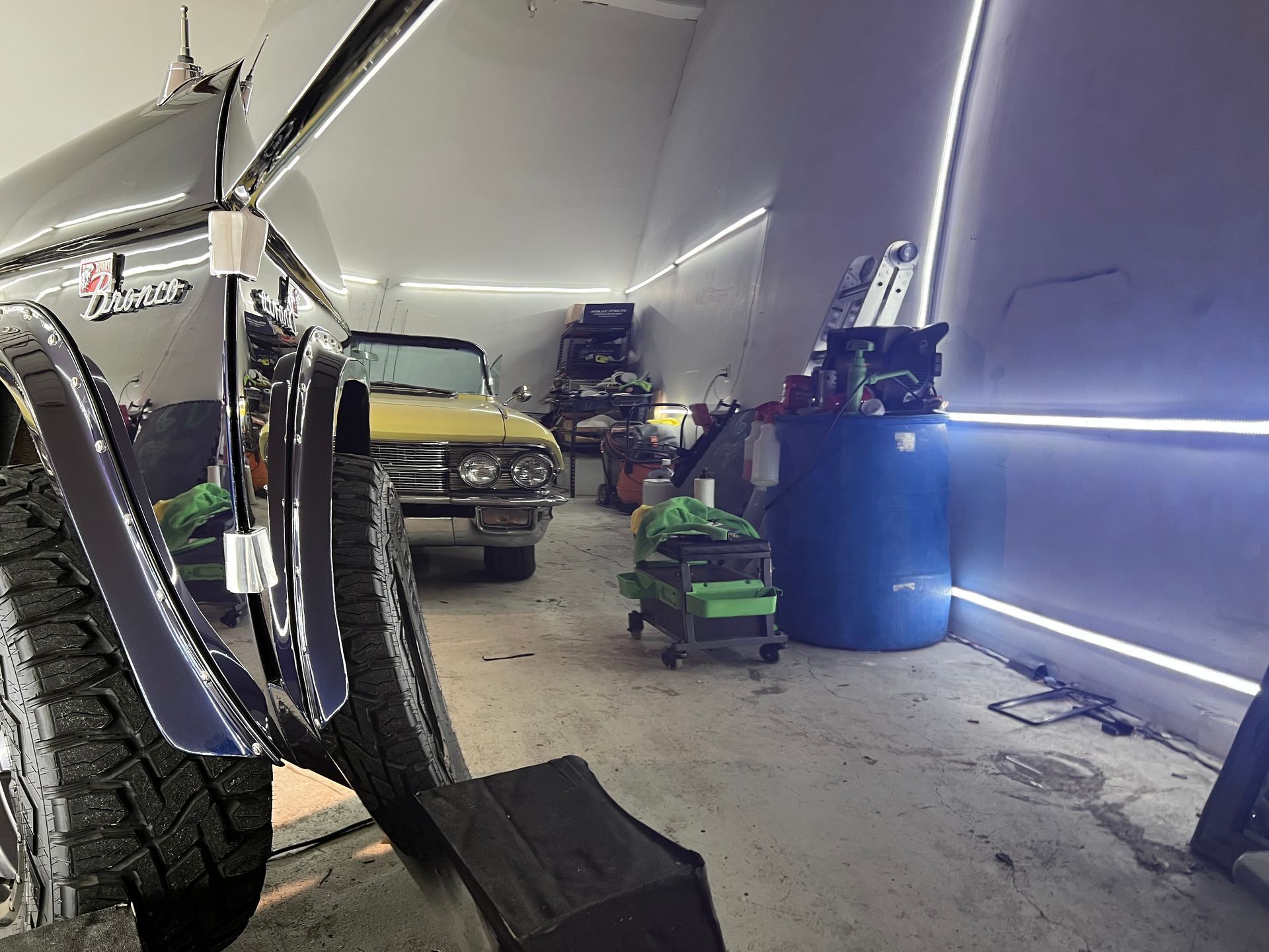 A car is parked in a garage with other cars.