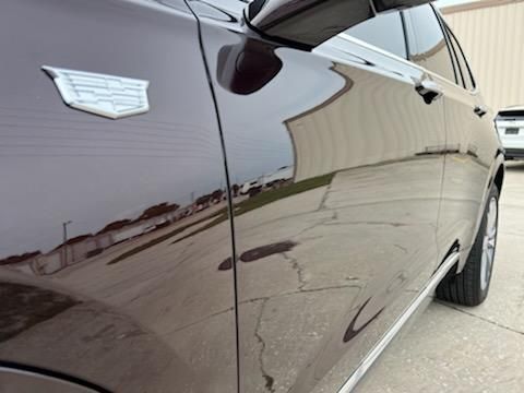 A close up of a black car parked in a parking lot.
