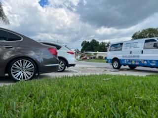 Two cars are parked next to each other in a grassy field.