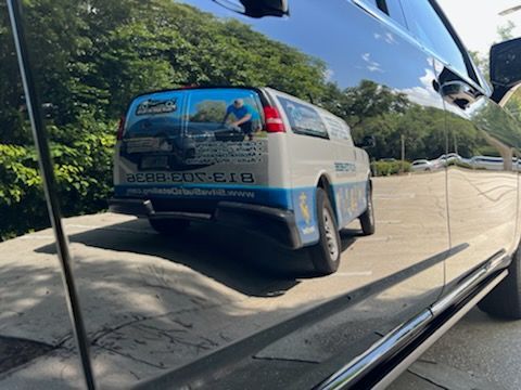 A blue and white van is parked in a parking lot.