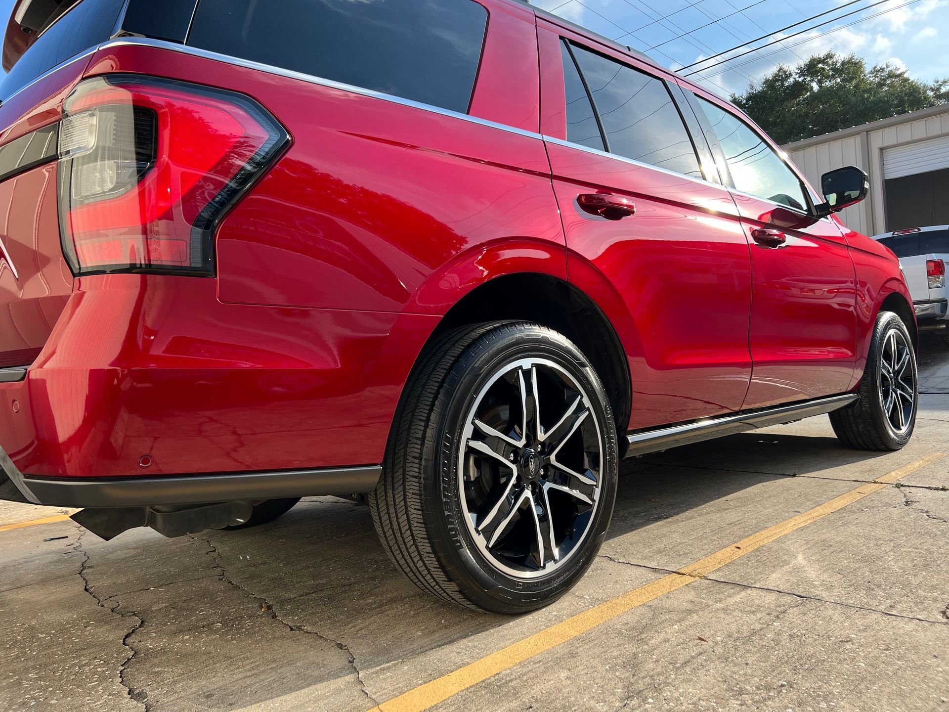 A red ford expedition is parked in a parking lot.