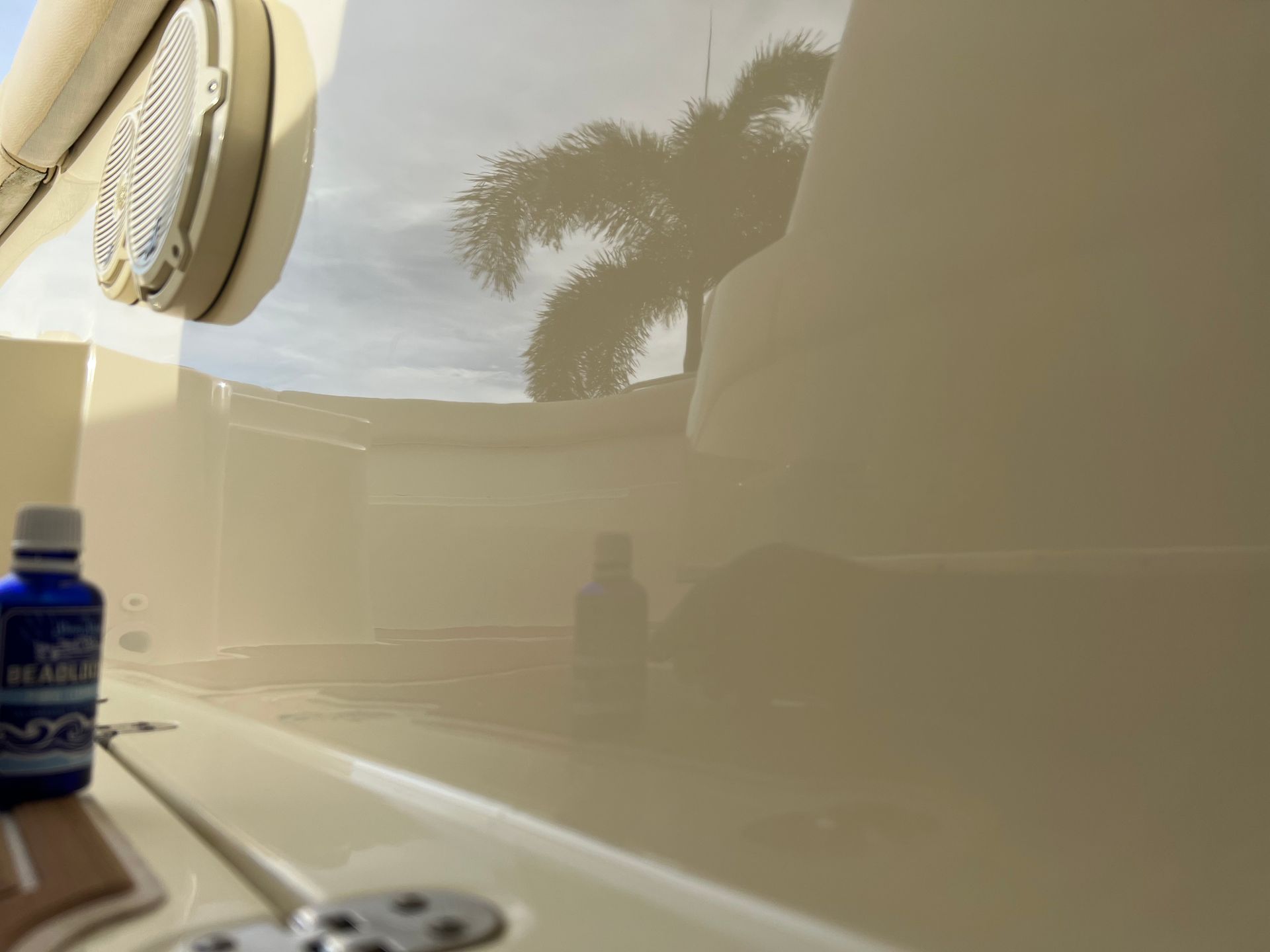 A bottle of blue liquid is sitting on the side of a boat.