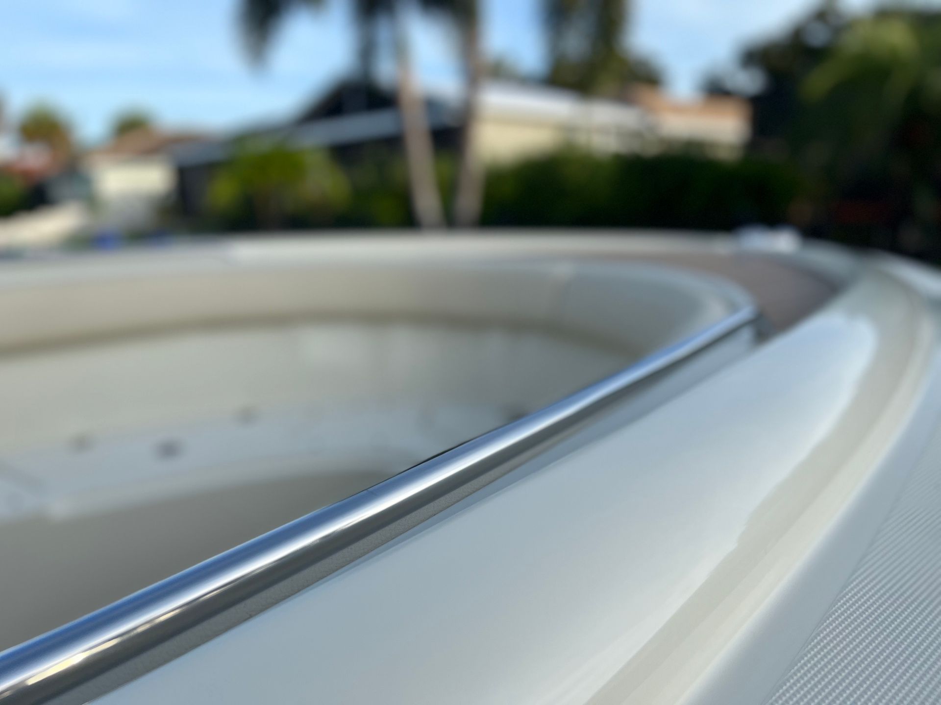A close up of a boat 's bow with a palm tree in the background.