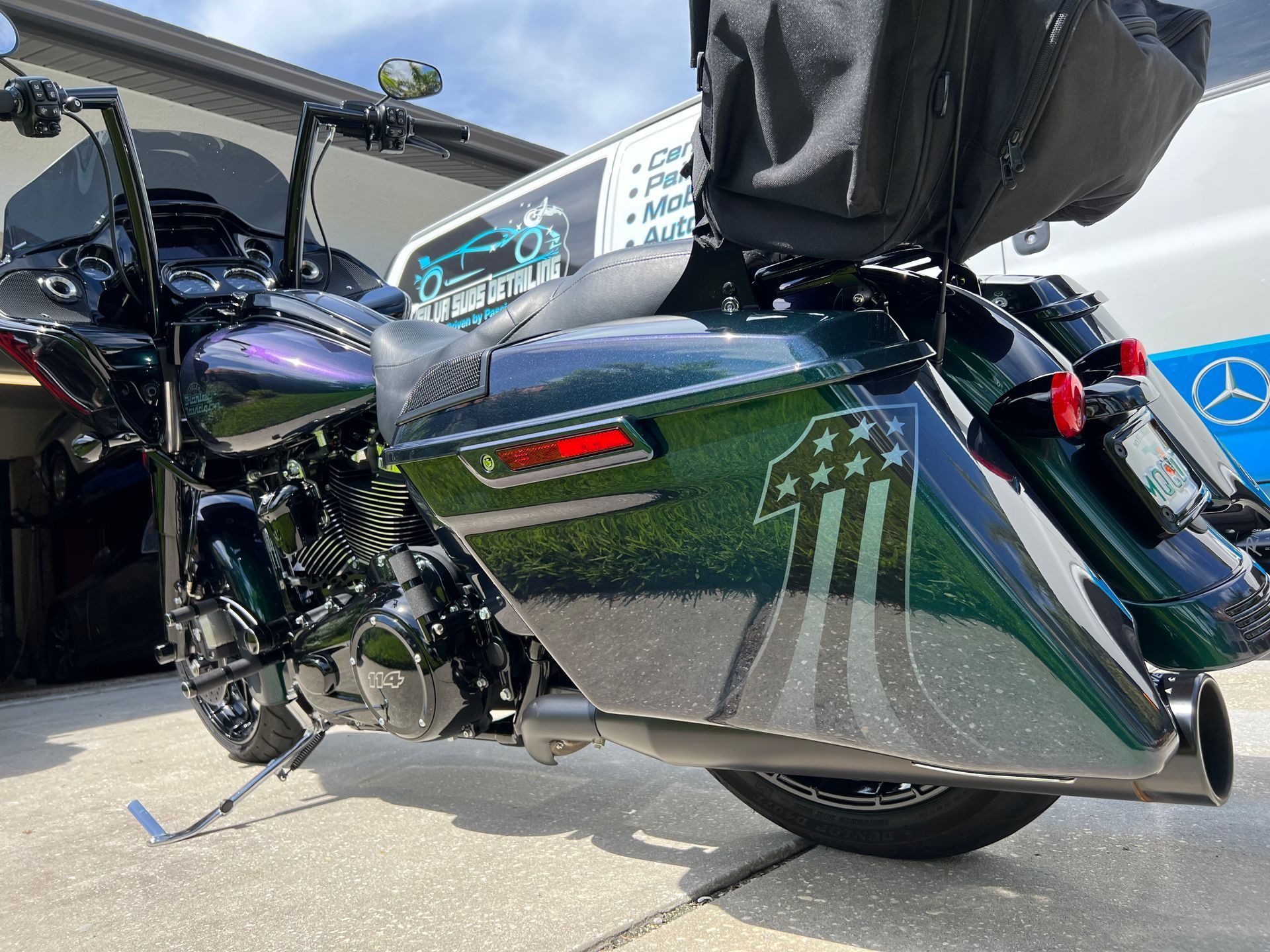 A harley davidson motorcycle is parked on the sidewalk in front of a house.
