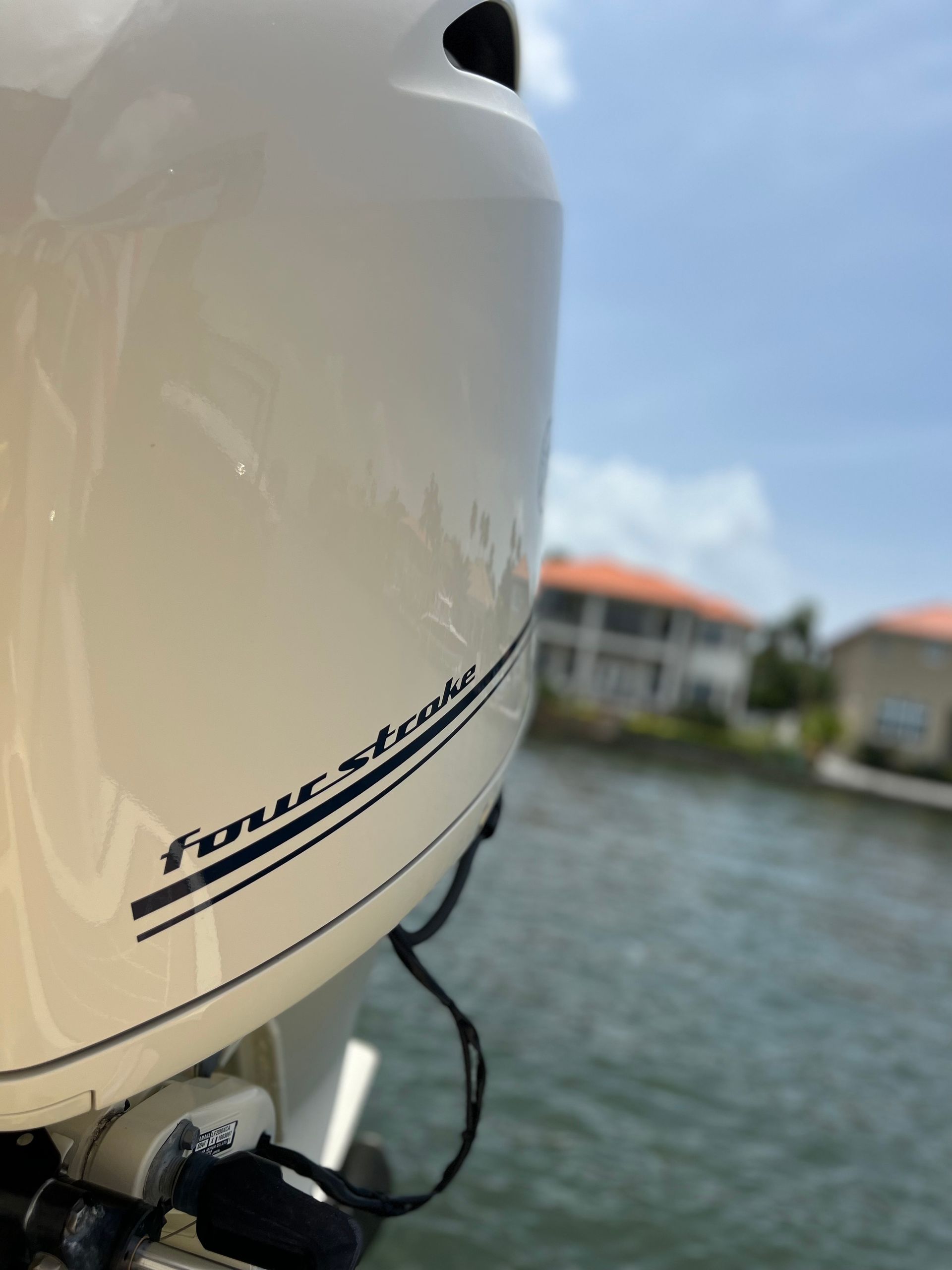A white outboard motor is sitting on top of a body of water.