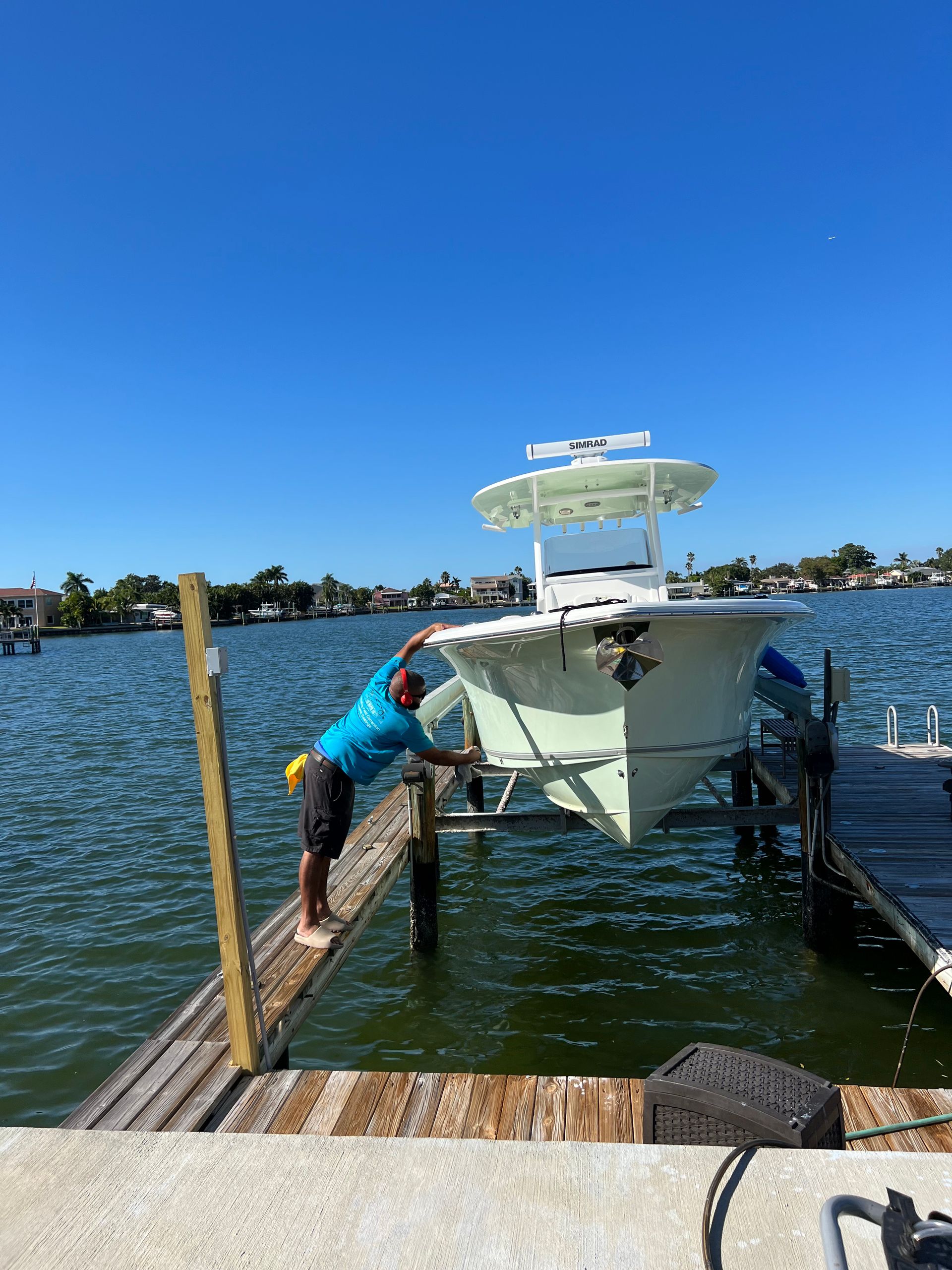A man is standing on a dock next to a boat.