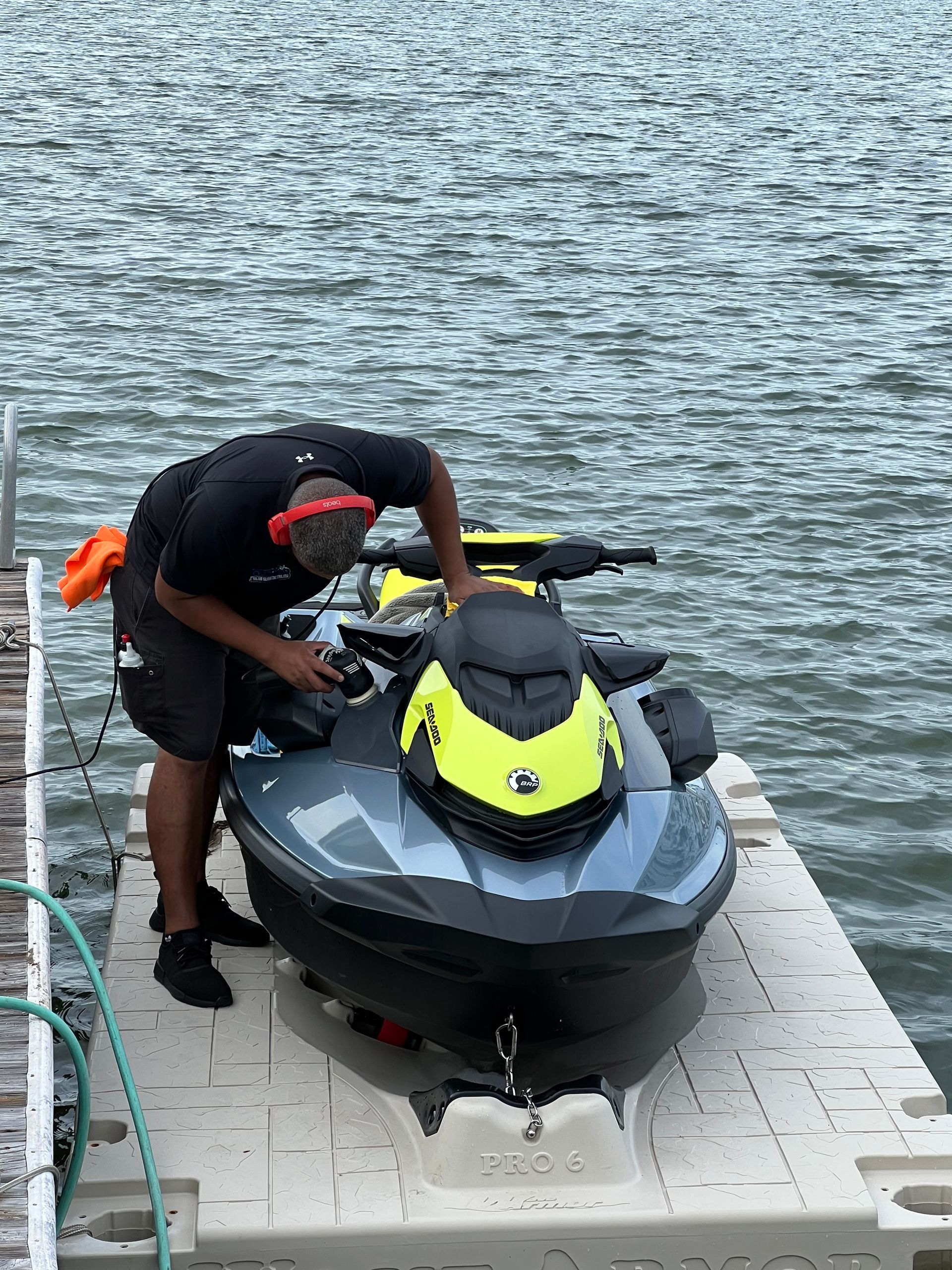 A man is working on a jet ski on a dock.