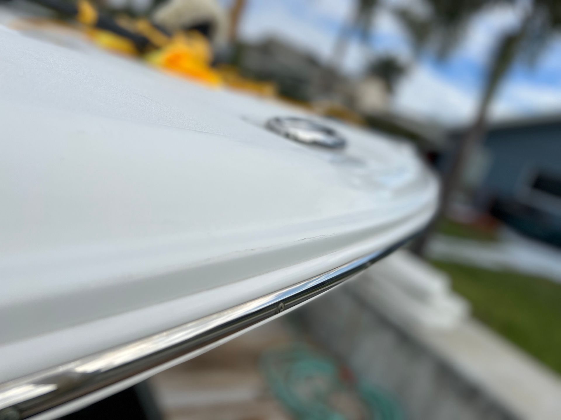 A close up of a white boat with a stainless steel trim.