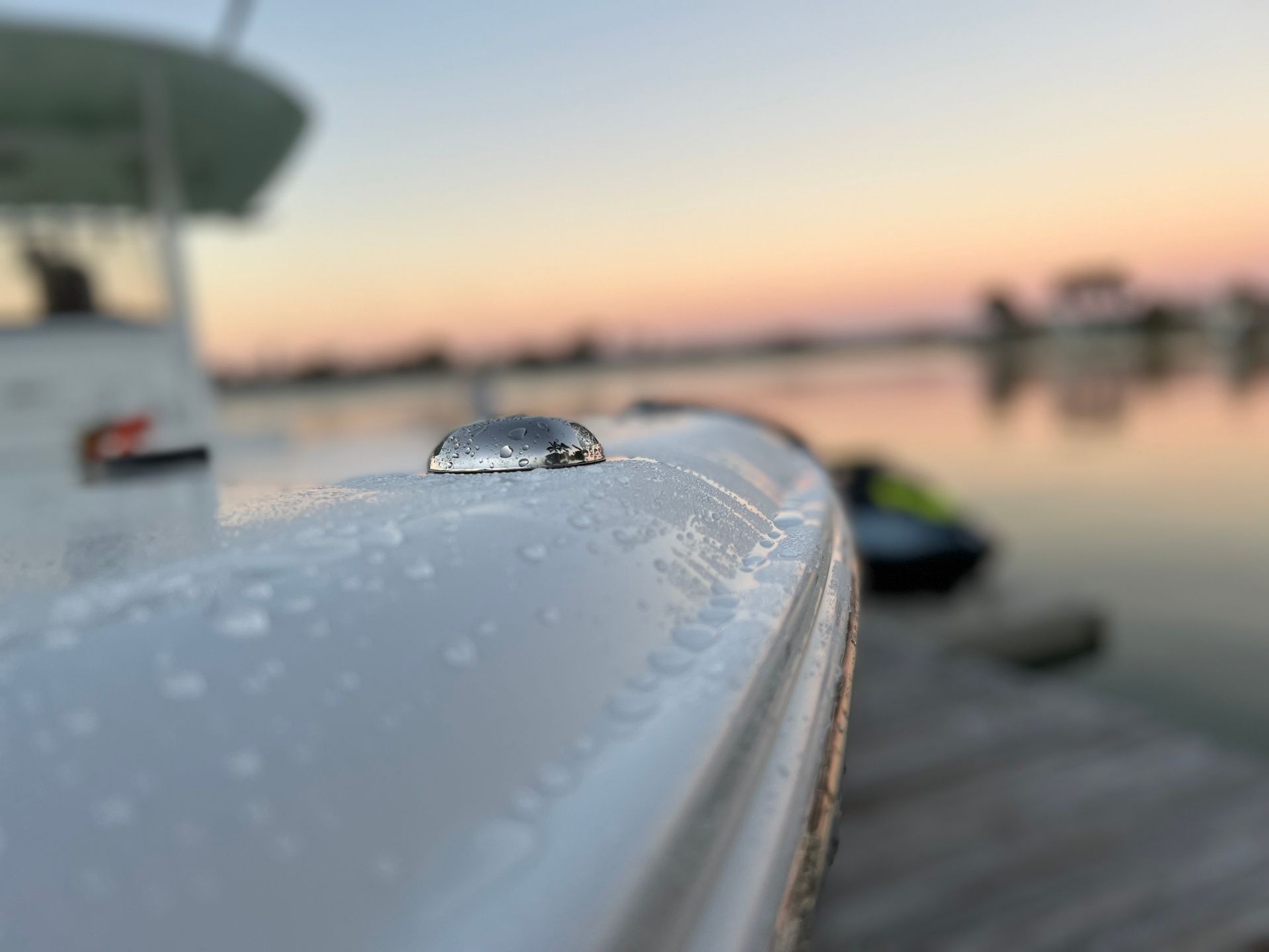 A close up of a boat 's side with a sunset in the background.