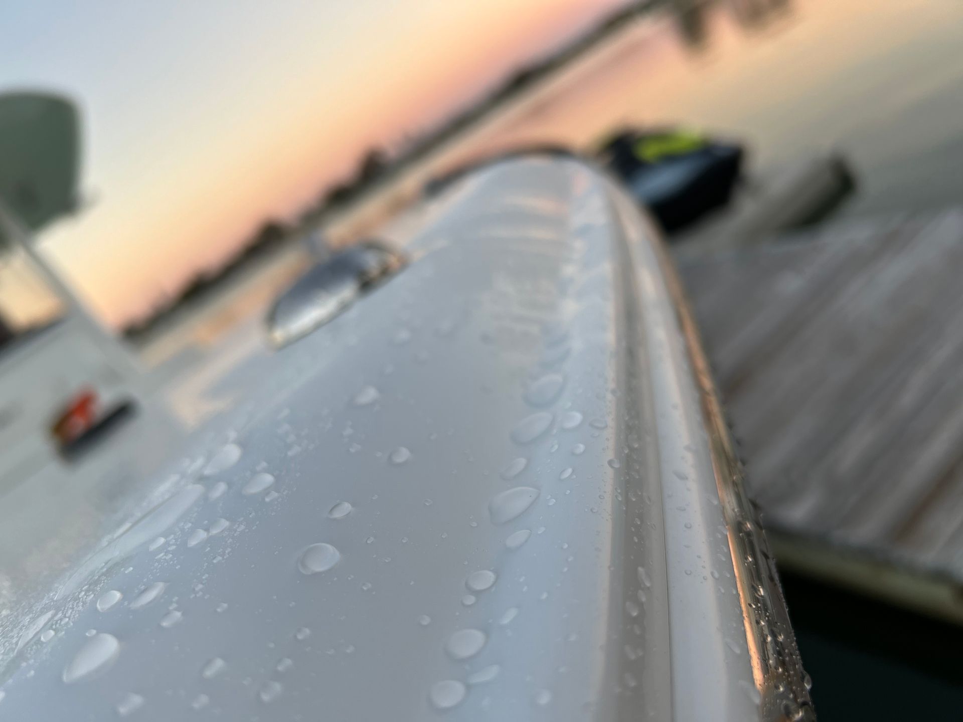 A close up of a boat 's side with water drops on it.