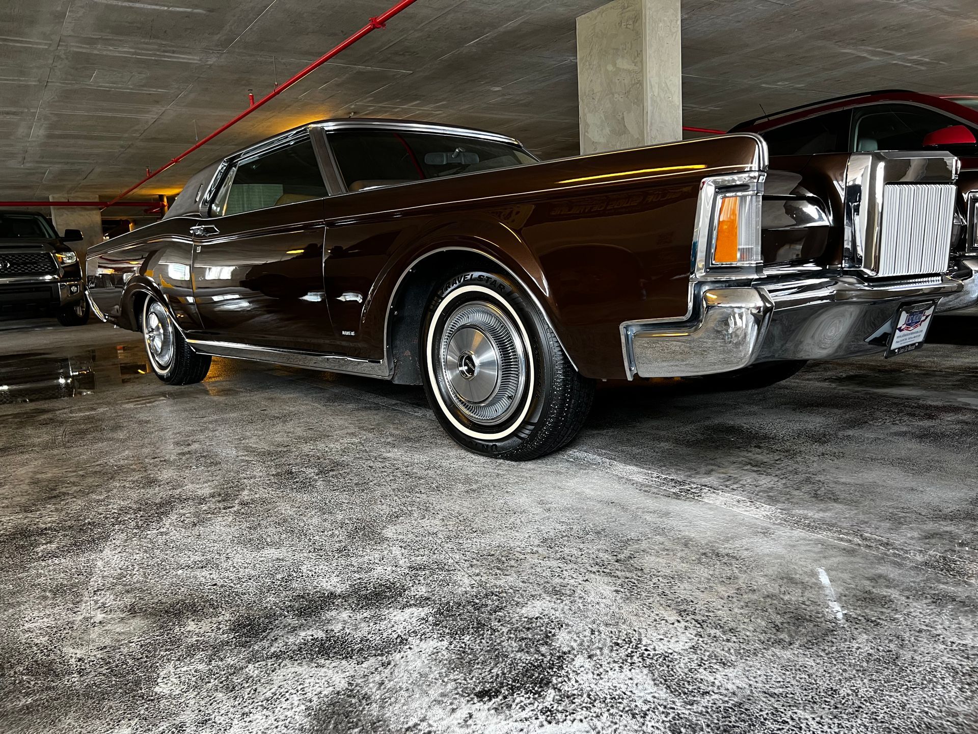A brown lincoln continental is parked in a parking garage.