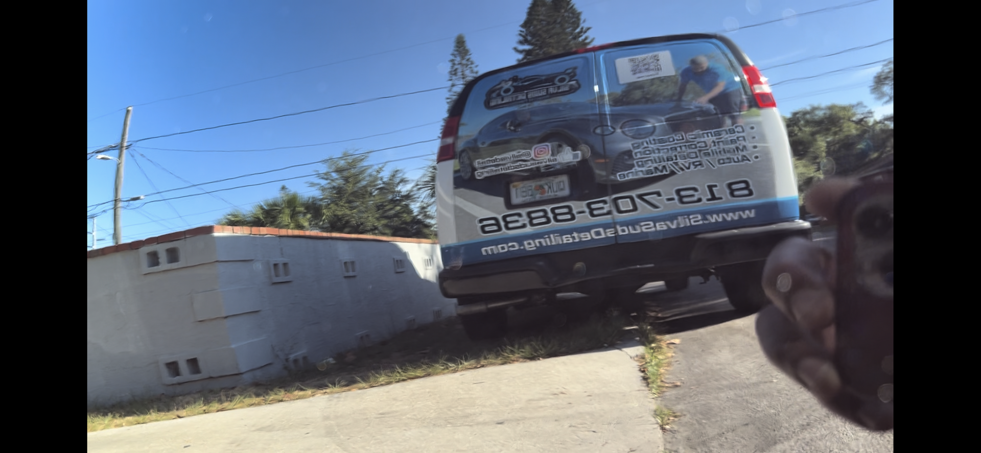 A blue and white van is parked on the side of the road.