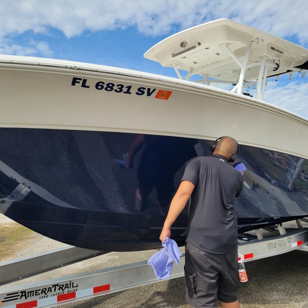 A man is standing next to a boat with the license plate fl 6831 sv
