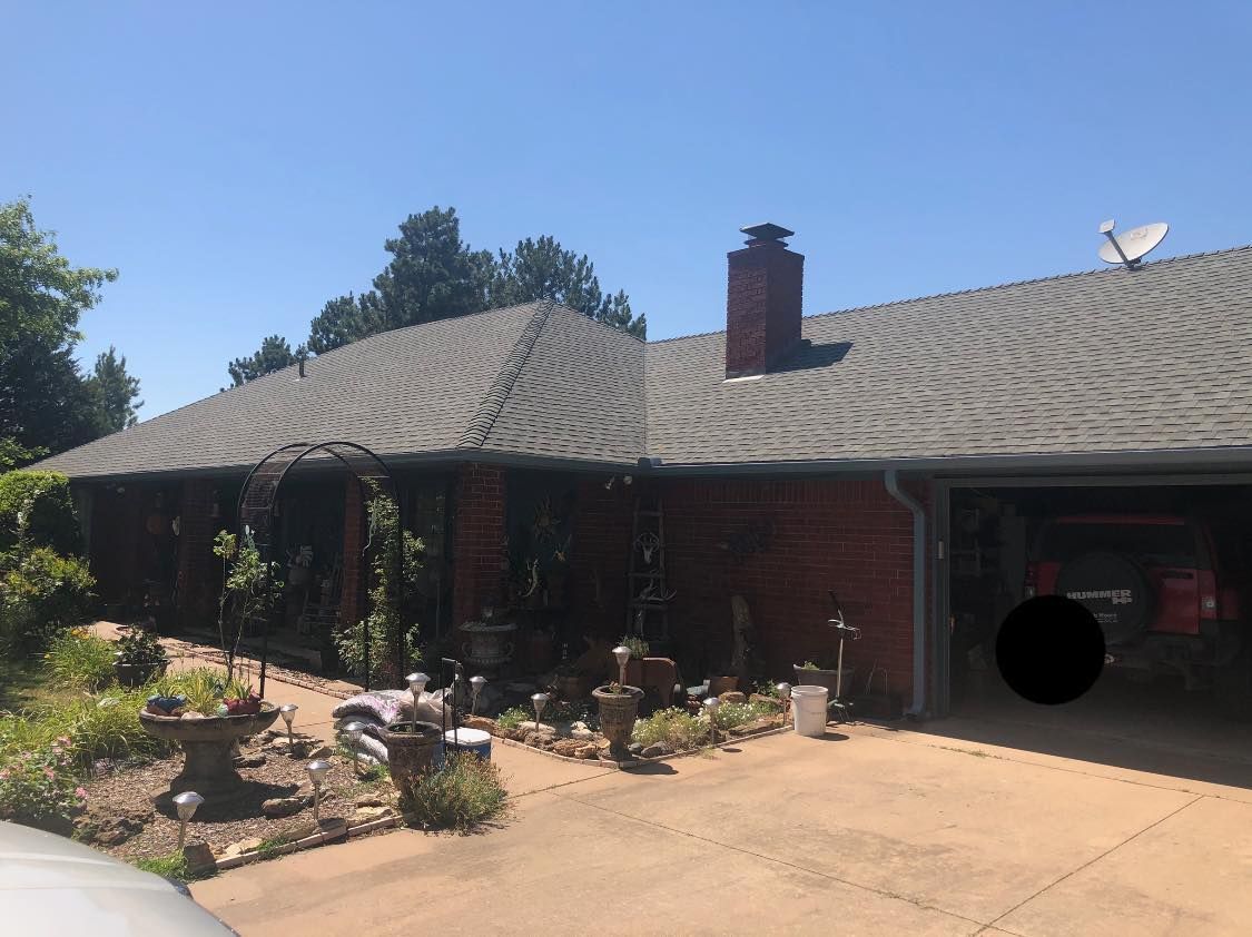 A red brick house with a satellite dish on the roof.