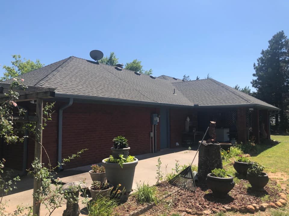 A large brick house with a satellite dish on the roof.
