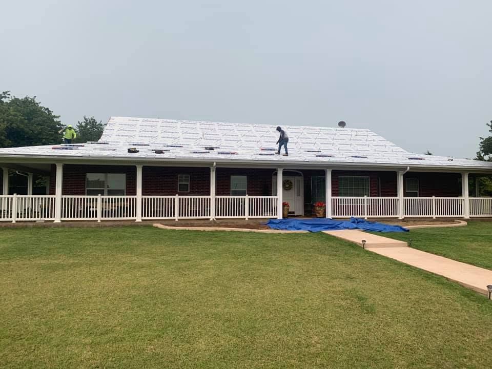 A man is standing on the roof of a house.