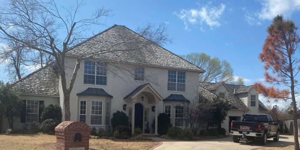 A large white house with a truck parked in front of it.