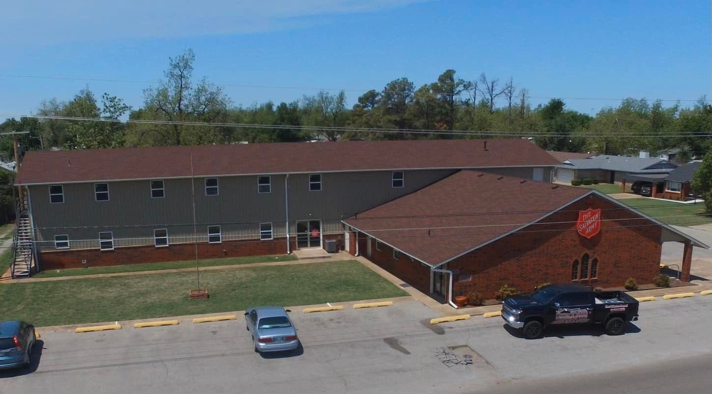 An aerial view of a large brick building with cars parked in front of it.