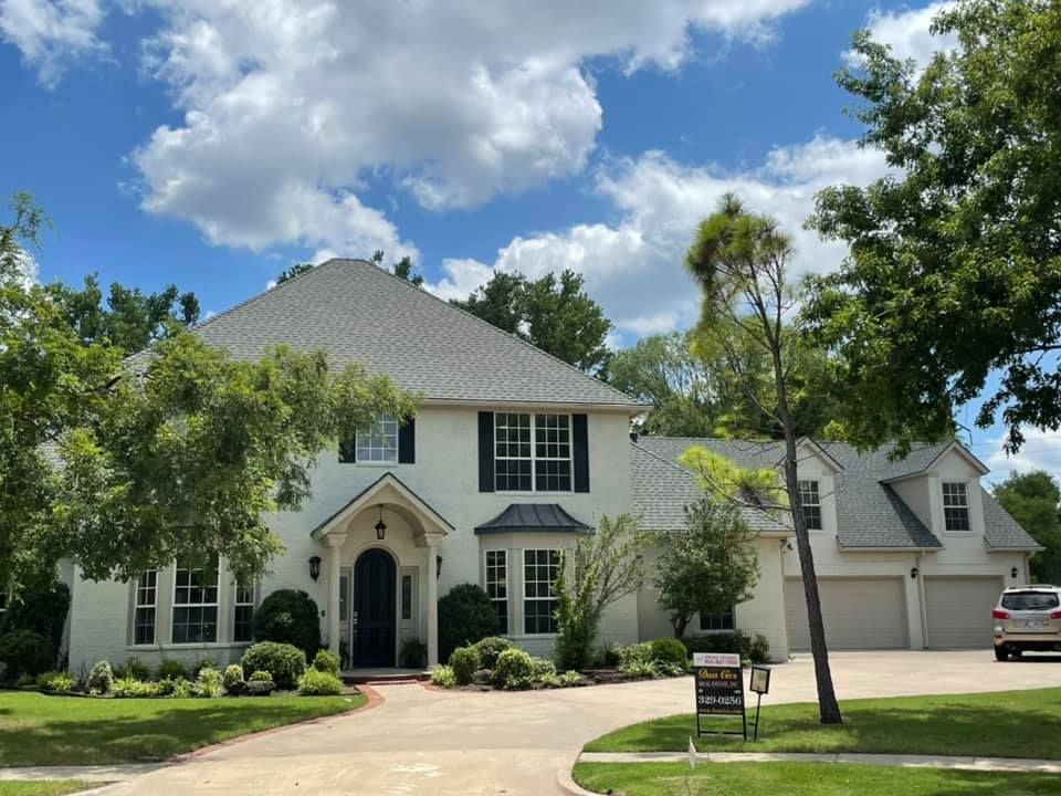A large white house with a for sale sign in front of it