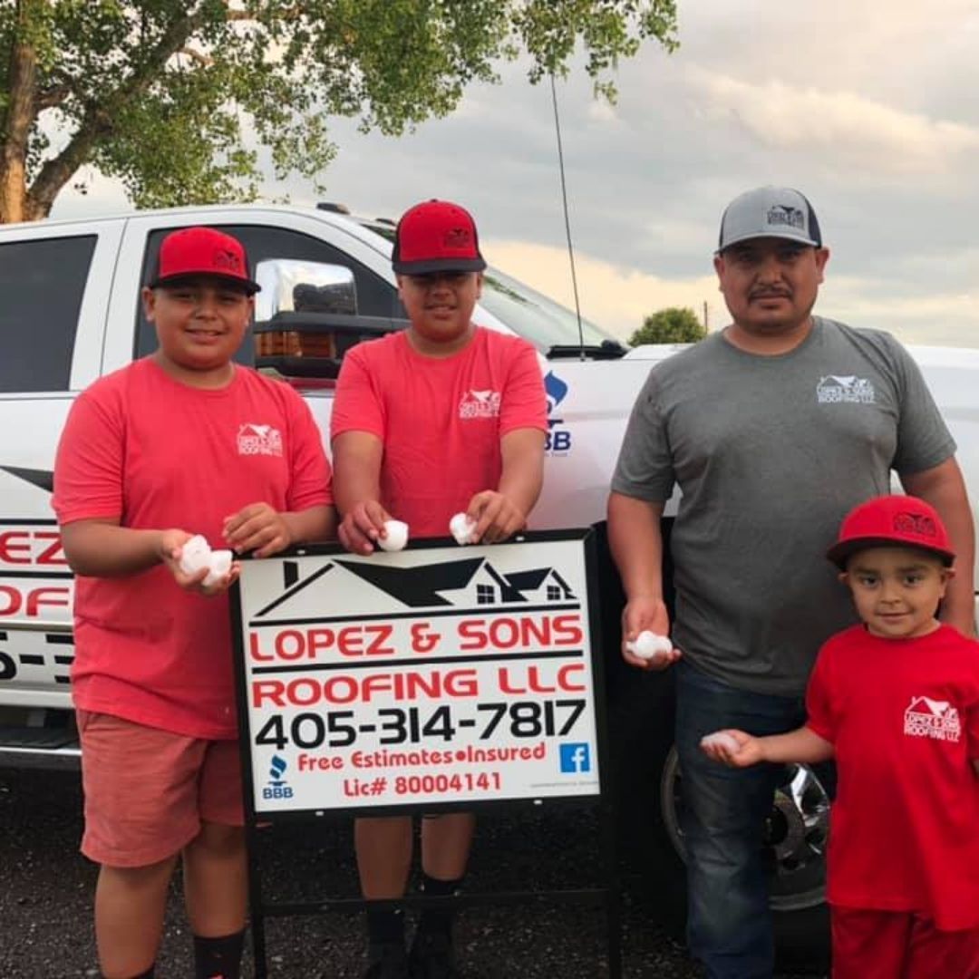 A group of men standing in front of a truck that says lopez & sons roofing llc
