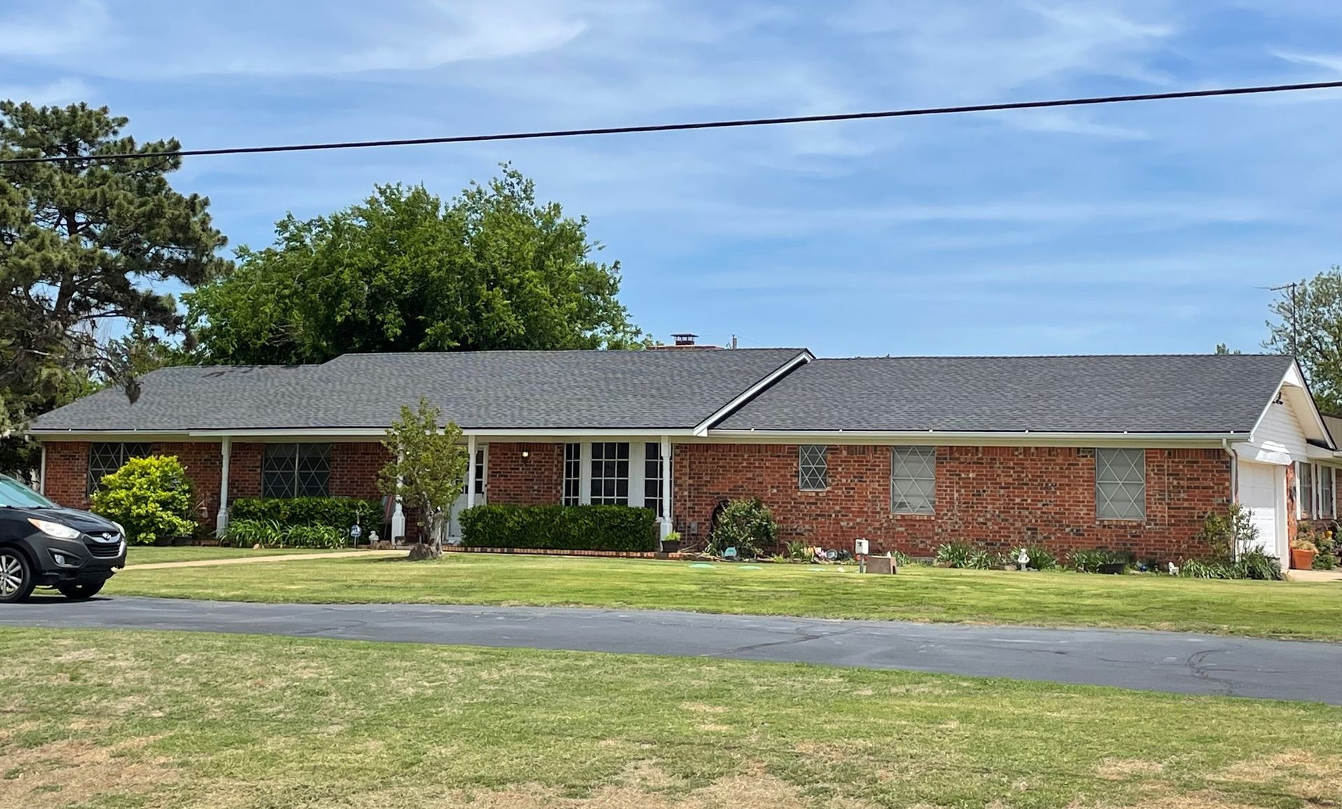 A brick house with a car parked in front of it.