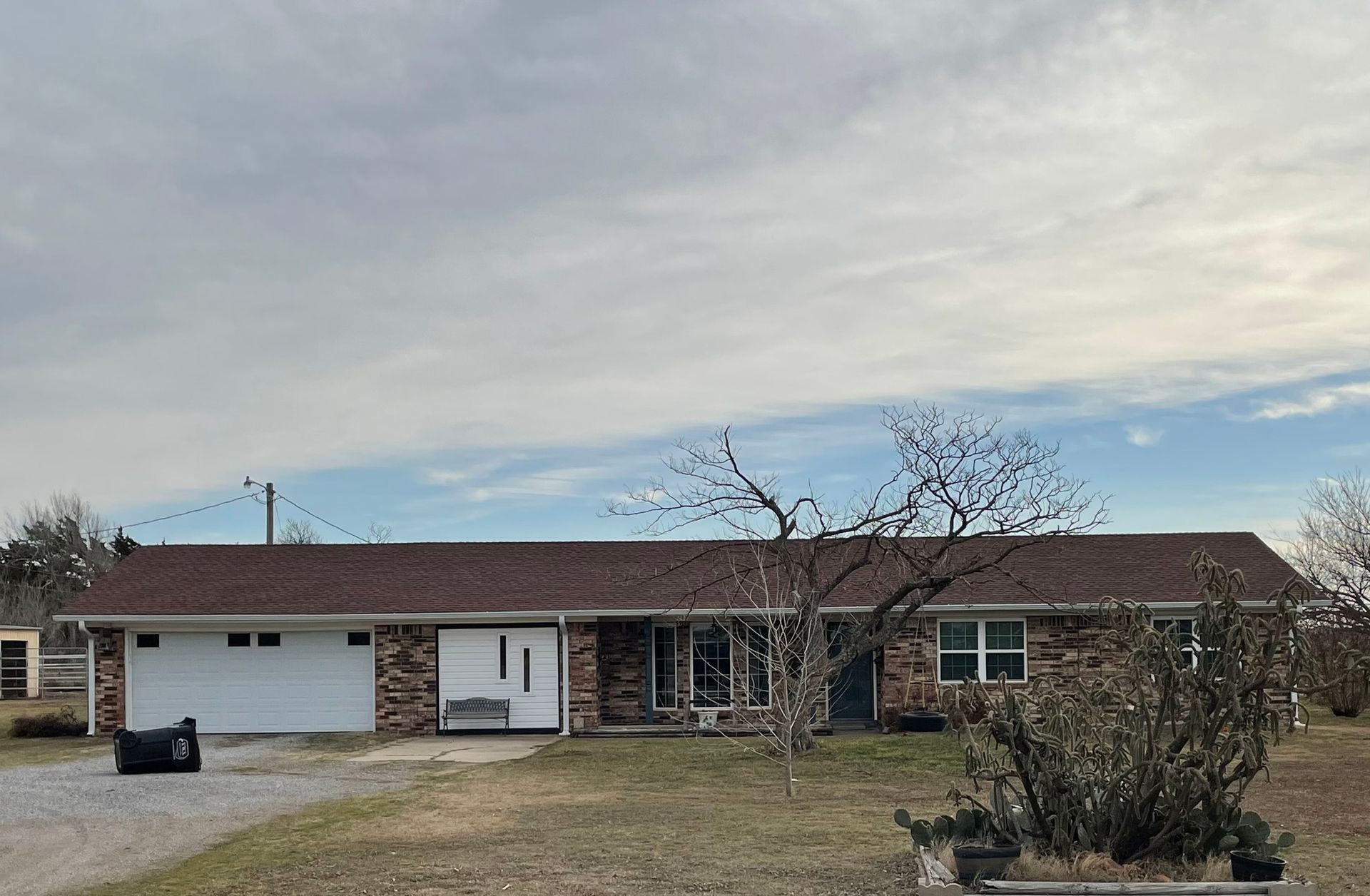 A large brick house with a brown roof and a white garage door.