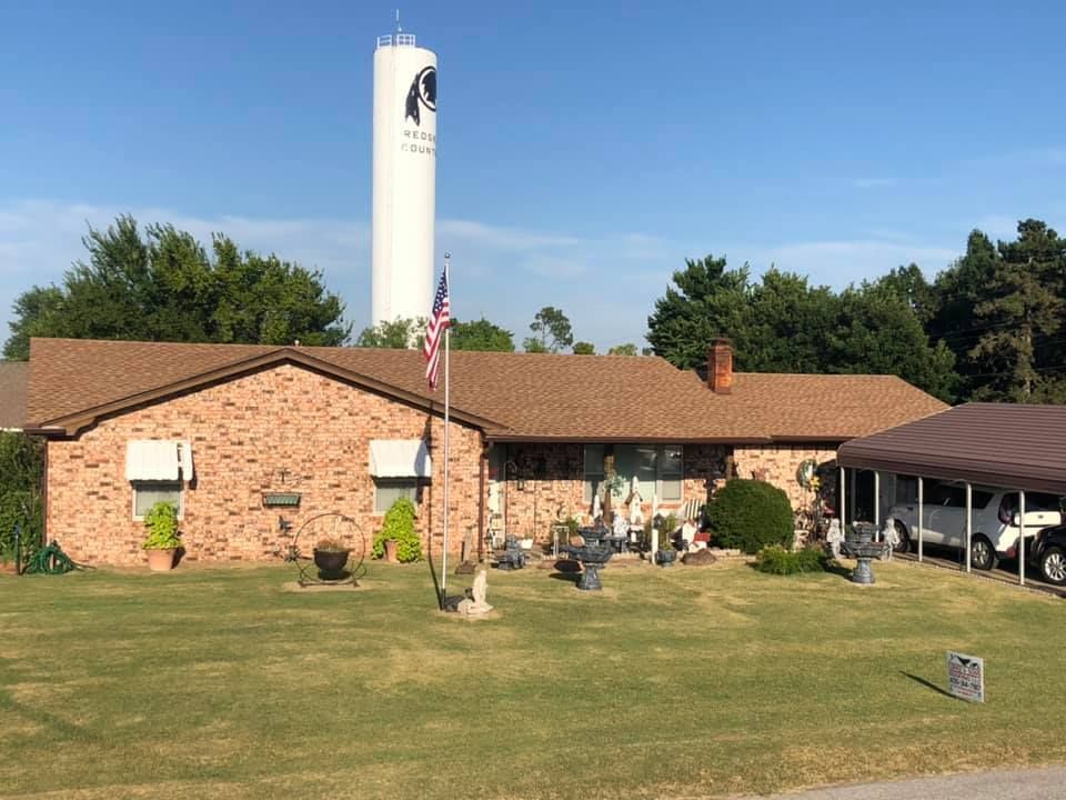 A brick house with a white water tower in the background.