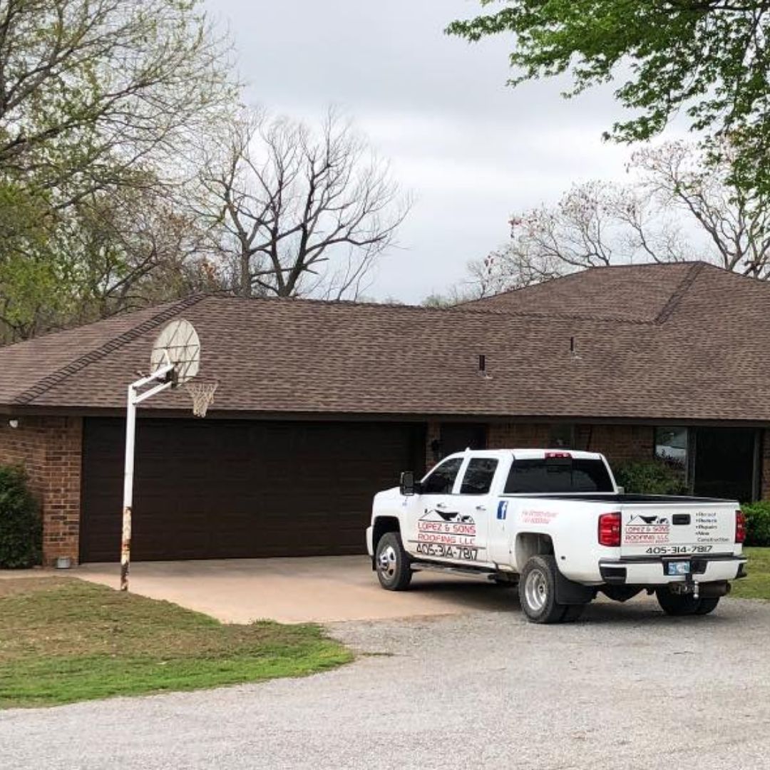 A white truck is parked in front of a house