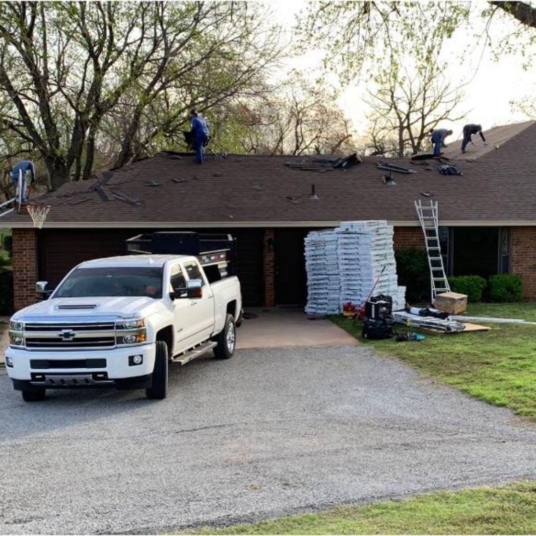 A white truck is parked in front of a house that is being remodeled.