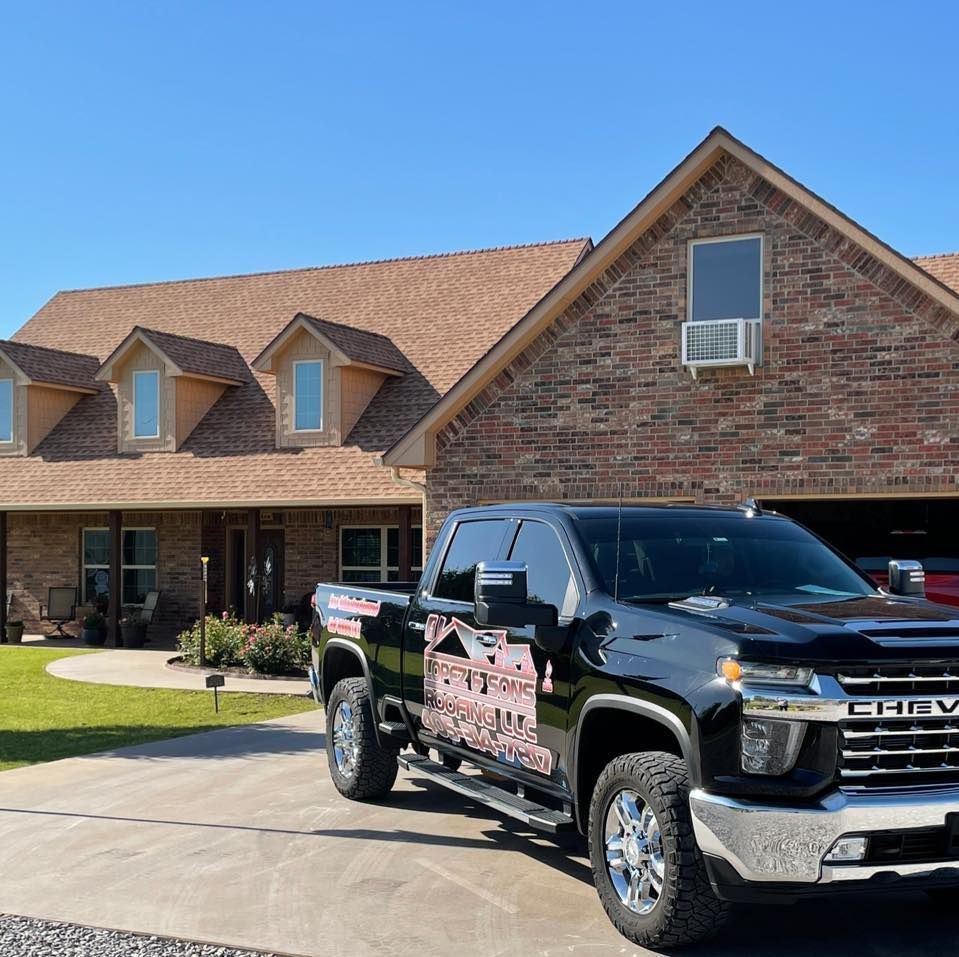 A black chevrolet truck is parked in front of a brick house