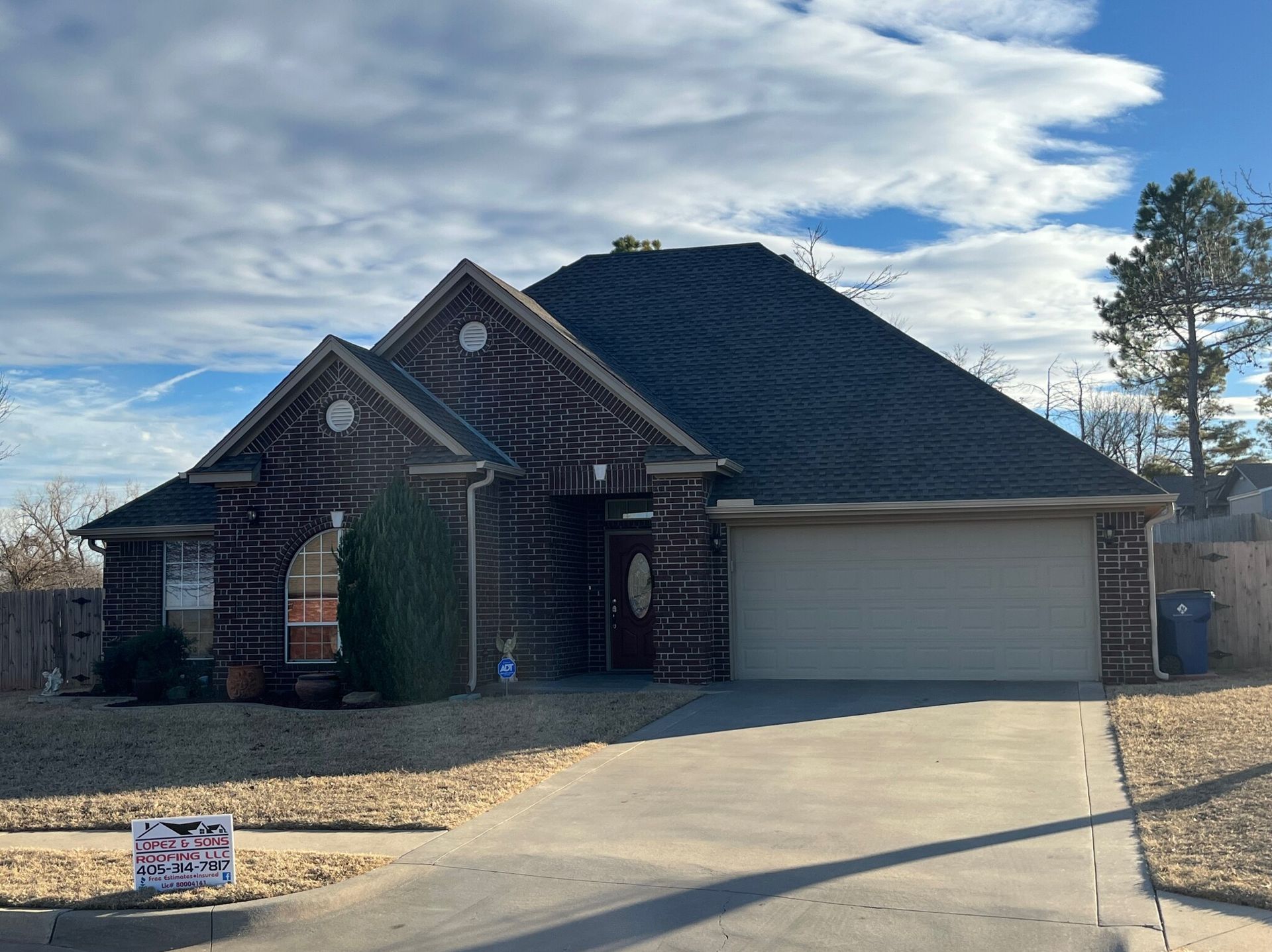 A large house with a large driveway and a sign in front of it.