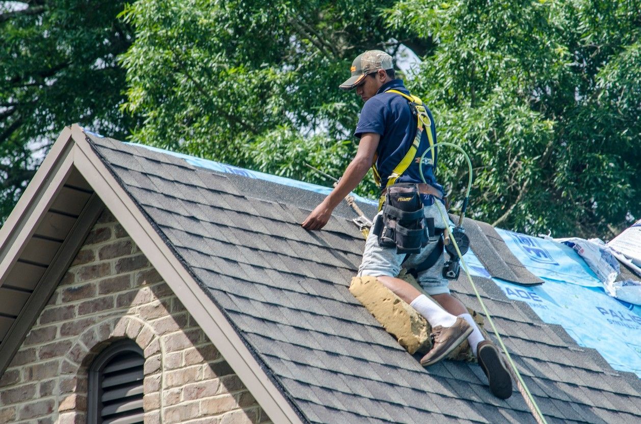 A man is working on the roof of a house.