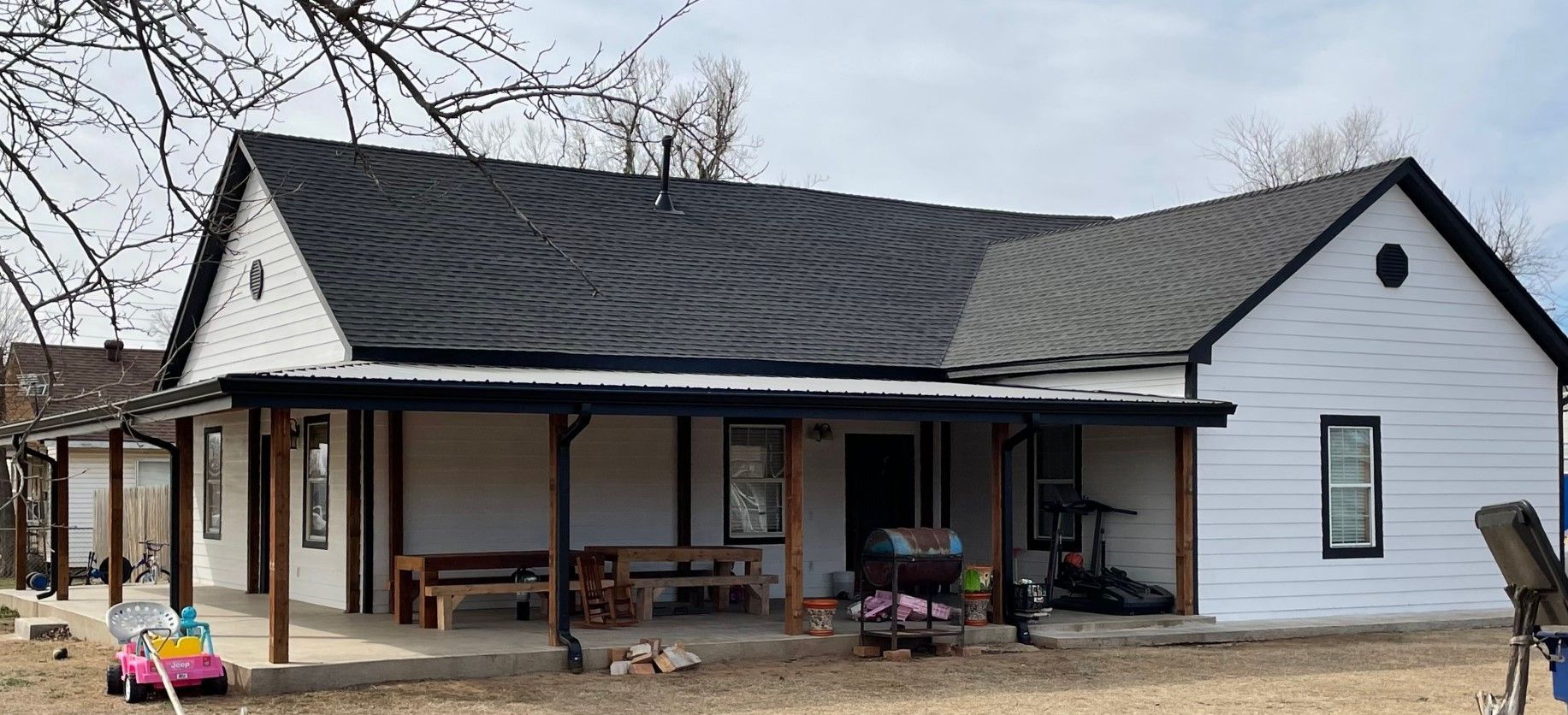 A brick house with a garage and a fence in front of it.