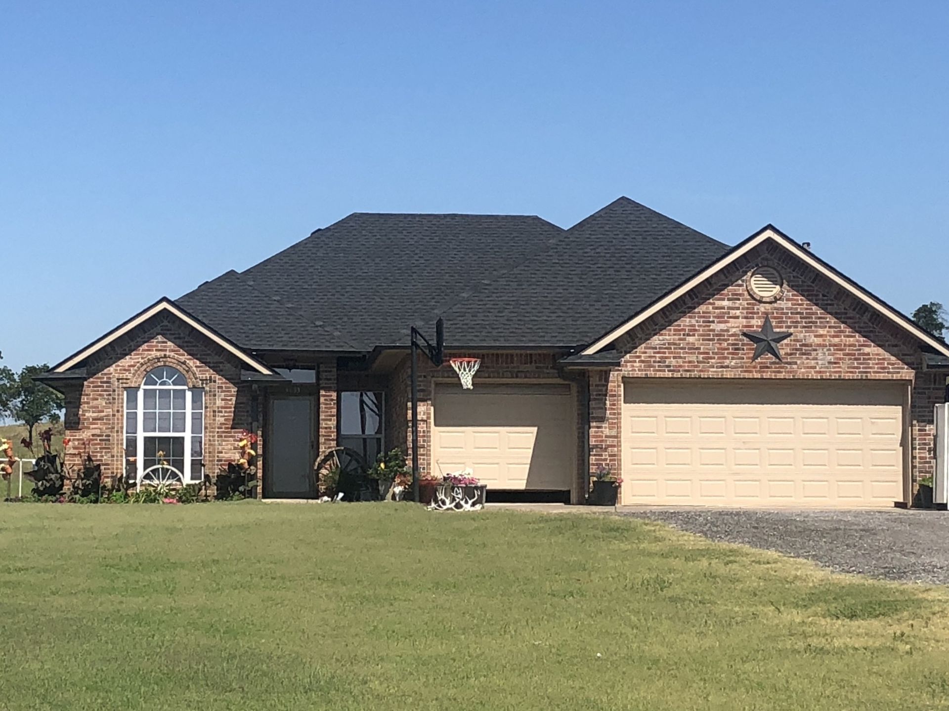 A brick house with two garage doors and a star on the front