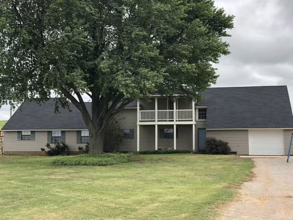 A house with a large tree in front of it
