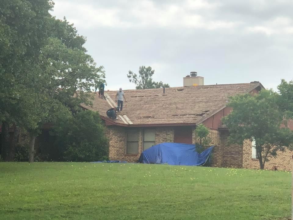 Two men are working on the roof of a house.