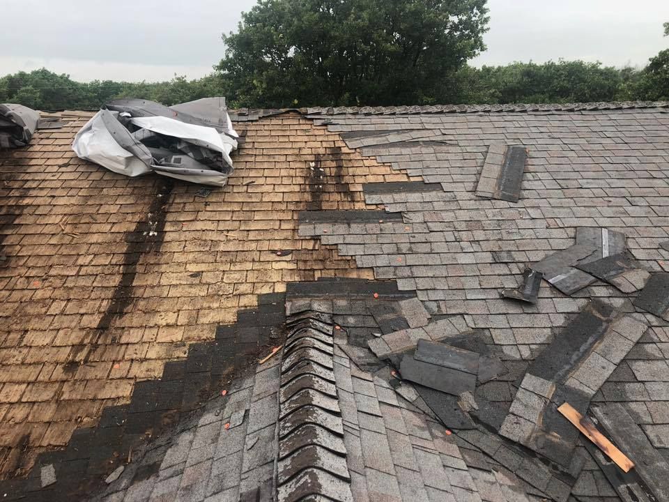 A roof with a lot of shingles on it is being repaired.