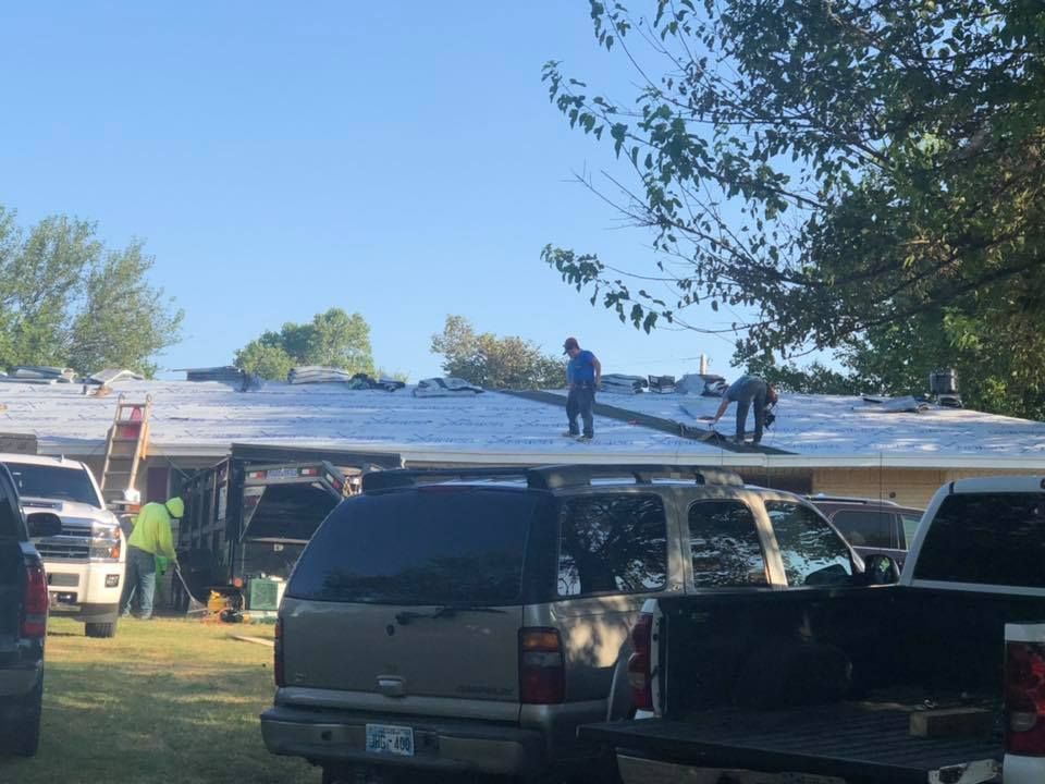 A group of people are working on the roof of a house.